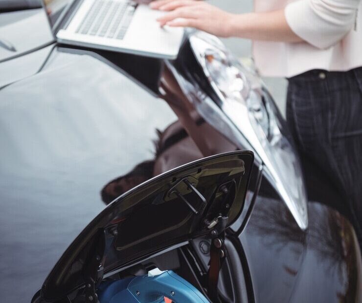 mid-section-woman-using-laptop-while-charging-electric-car_107420-94903 mid-section-woman-using-laptop-while-charging-electric-car_107420-94903