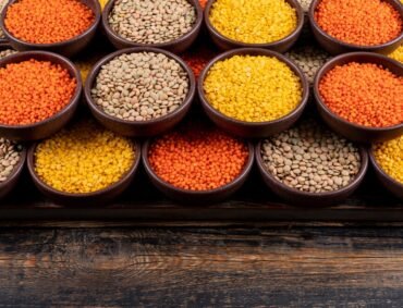 some-yellow-green-red-lentils-brown-bowls-dark-wooden-table-high-angle-view_176474-2178