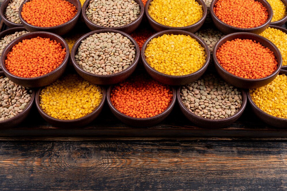 some-yellow-green-red-lentils-brown-bowls-dark-wooden-table-high-angle-view_176474-2178