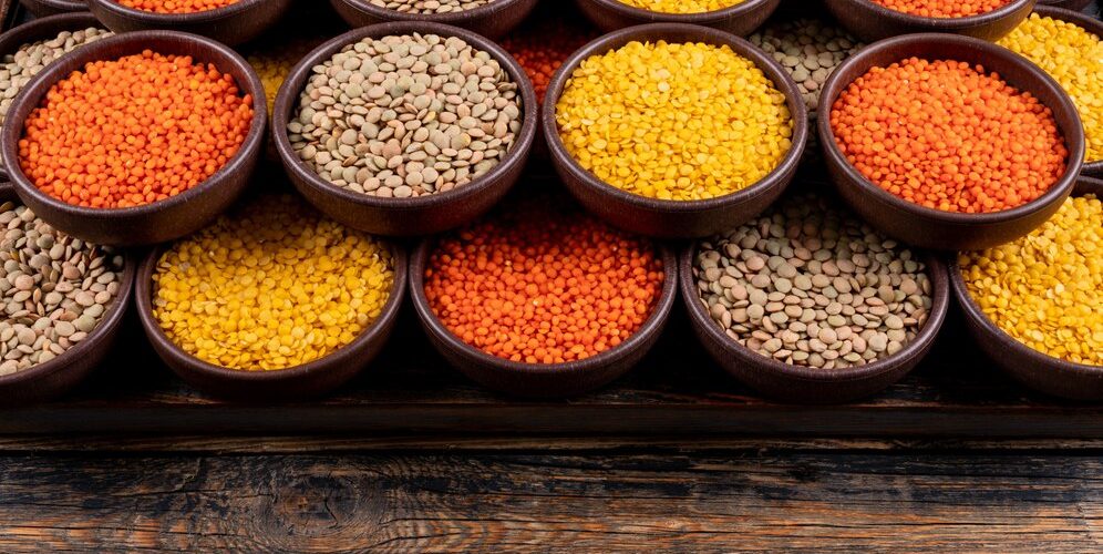 some-yellow-green-red-lentils-brown-bowls-dark-wooden-table-high-angle-view_176474-2178